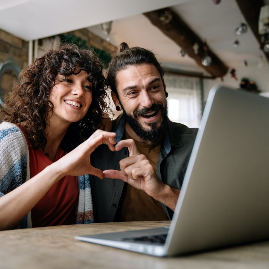 young-smiling-couple-having-online-family-video-call-at-home